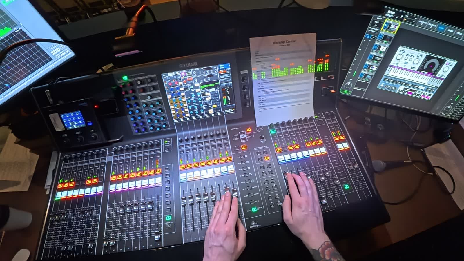 Hands on a mixing console at front of house