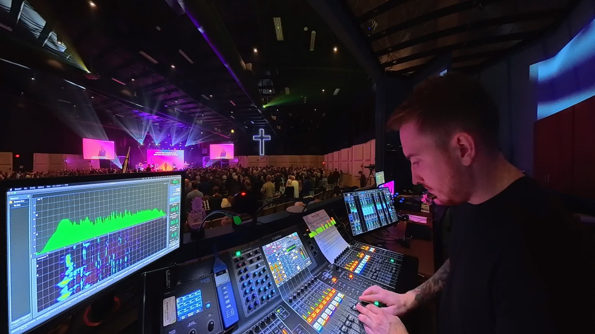 JJ Smith mixing front of house at a packed Pathway Community Church service, stage lit in purple behind his console